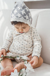 Baby wearing the Avauma Cream Bodysuit in Spring Forest print – highlighting the comfortable wrap-style design and subtle floral details perfect for everyday infant wear.